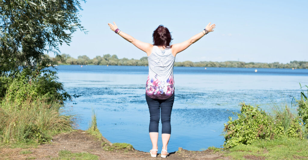 A woman doing yoga by a lake