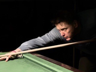 Peter Ely, hypnotherapist in Islington, lining up a shot at the snooker table.